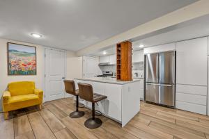 a kitchen with white cabinets and a yellow chair at Jersey City Retreat w Private Backyard Bonfire Near NYC in Jersey City