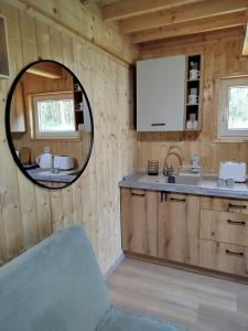 a kitchen with a round mirror and a sink at Jeziorna Ostoja in Jodlow +29 photos
