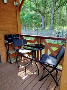 a porch with a table and chairs on a cabin at Jeziorna Ostoja in Jodlow
