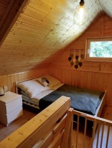 a bedroom with a bed in a wooden cabin at Jeziorna Ostoja in Jodlow