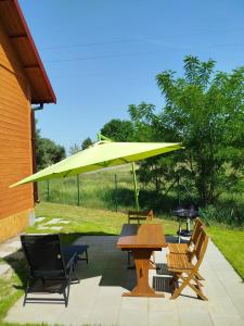 a yellow umbrella on a patio with chairs and a table at Jeziorna Ostoja in Jodlow