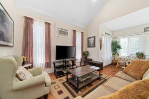 een woonkamer met een bank en een tv bij The Sumac - 8 Natures in Cherry Valley