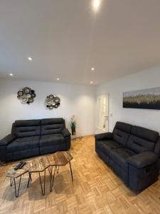 - un salon avec deux canapés noirs et une table dans l'établissement Stielvolle Etagenwohnung in bester Lage, à Rodenbach 7 autres photos