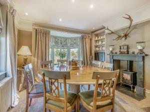 a dining room with a table and chairs and a fireplace at Willington Lodge in Hanmer