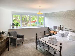 Saint Margarets HopeにあるThe Legionのベッドと椅子と窓のある寝室