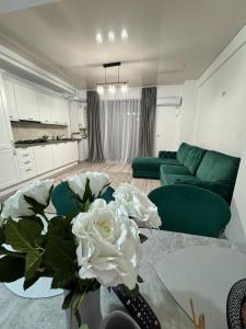 a living room with a vase with white flowers on a table at Ana Derol in Năvodari