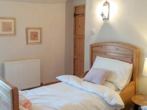 a bedroom with a bed with two pillows on it at May Cottage in Bakewell +3 photos