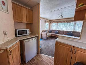 una cucina con forno a microonde e un soggiorno di Fantastic 4 Berth Caravan In Skegness With Private Hot Tub Ref 96023H a Skegness Altre 12 foto