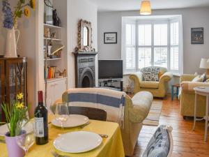a living room with a table and chairs and a fireplace at Blue Cottage in Broadstairs