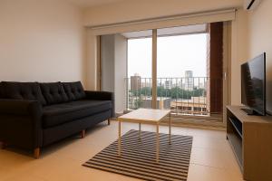 a living room with a couch and a large window at NUEVO Puerto Norte con cochera opcional in Rosario