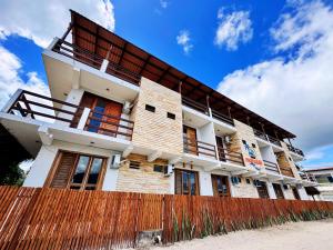 a building with a wooden fence in front of it at Pousada Mahalo Preá Beach in Prea