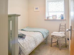 una piccola camera con letto e sedia di Mansefield Cottage a Boyndie