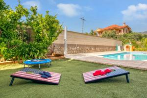 two mats on the grass next to a swimming pool at Casa Gredos- Chimenea , Setas , BBQ , Relax in Mombeltrán +38 photos