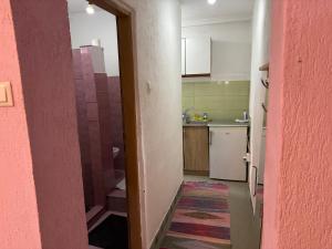 GoraždeにあるApartments Jasminのピンクの壁と出入り口のある小さなキッチン +12枚の写真