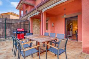 a wooden table and chairs on a patio at Casa Gredos- Chimenea , Setas , BBQ , Relax in Mombeltrán