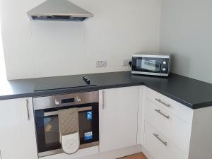 a kitchen with a microwave and a stove at The Red Kite - Uk31003 in Avoch