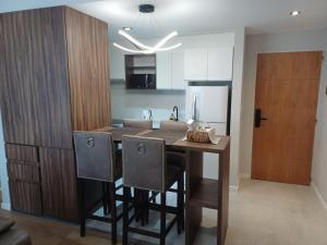 a kitchen with a table with chairs and a refrigerator at Bonhomía Torre Quartz in Neuquén