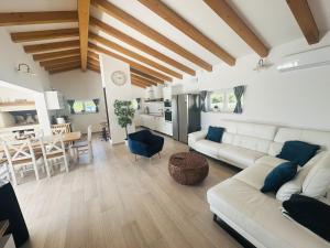a living room with a white couch and a kitchen at Villa V in Svetvinčenat