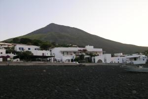a group of white buildings with a mountain in the background at La Sirenetta Park Hotel in Stromboli
