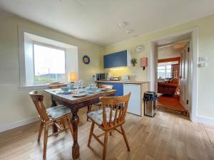 a kitchen and dining room with a table and chairs at Dalcharn in Bettyhill