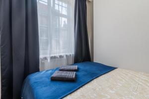 a bed with two towels sitting on it in front of a window at Holy Spirit Street Apartments in Gdańsk