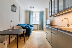 a kitchen and living room with a blue couch at Holy Spirit Street Apartments in Gdańsk