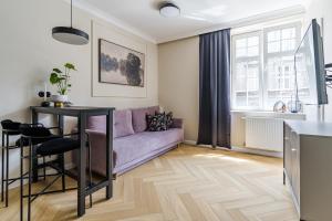 a living room with a purple couch and a table at Holy Spirit Street Apartments in Gdańsk