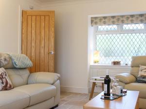 a living room with a couch and a table at Rhunahaorine Cottage in Gortinanane