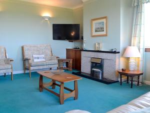 a living room with a fireplace and a tv at Bel-Mar in Whithorn