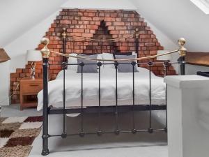 a bedroom with a bed in front of a brick wall at Hill View in Abertillery