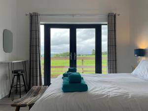 a bedroom with a bed with a view of a field at Willow Lodge in Muir of Ord