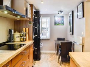 a kitchen with a black refrigerator and a table at The Cart House in Merthyr Cynog