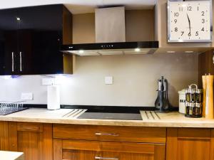 a kitchen with a stove and a clock on the wall at The Cart House in Merthyr Cynog