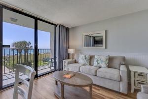 a living room with a couch and a table at 0210 Sun-Kissed Memories condo in Carolina Beach +17 photos
