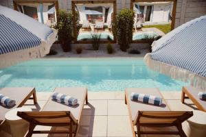 a swimming pool with two chairs and a table at Złota 34 Karwia in Karwia