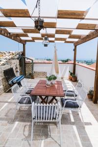 Un patio con una mesa y sillas de madera. en Villa Adriatica - Character Home, Costa dei Trabocchi, en Villalfonsina