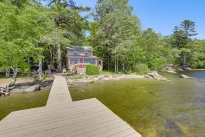 a house on the shore of a river with a dock at Dock, Beach, Views Rustic Green Lake Cottage in Otis