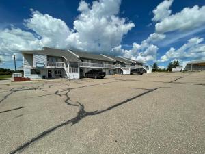 a building with a parking lot in front of it at Hilltop Motor Inn in Elk Point