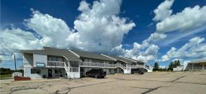 a building with a parking lot in front of it at Hilltop Motor Inn in Elk Point