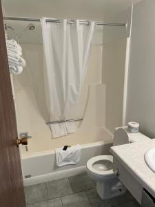 a bathroom with a toilet and a tub and a sink at Hilltop Motor Inn in Elk Point