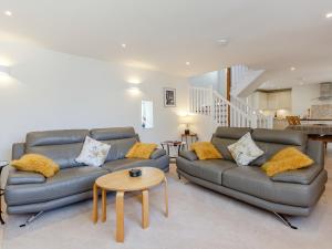 ein Wohnzimmer mit zwei Sofas und einem Tisch in der Unterkunft Willow Cottage - Uk39244 in Inverness