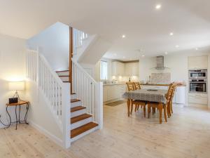 eine Küche und ein Esszimmer mit einer Treppe und einem Tisch in der Unterkunft Willow Cottage - Uk39244 in Inverness