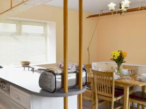 eine Küche und ein Esszimmer mit einem Tisch in der Unterkunft The White Cottage in Furness Vale