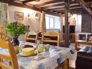 a dining room table with a cake and flowers on it at The Carthouse - Uk13184 in Cwm-Morgan