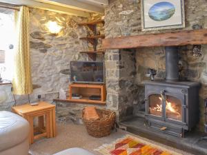 un soggiorno con camino e TV di Sanctuary Cottage ad Aberdaron Altre 12 foto