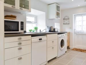 une cuisine avec un micro-ondes et un lave-linge et un sèche-linge dans l'établissement Seaton Cottage, à Collieston 15 autres photos