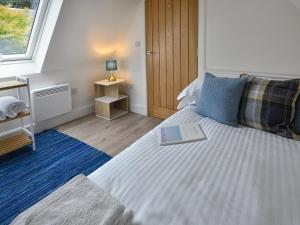 ein Schlafzimmer mit einem Bett, auf dem ein Buch liegt in der Unterkunft Harris Cottage - Uk40056 in Aberfeldy