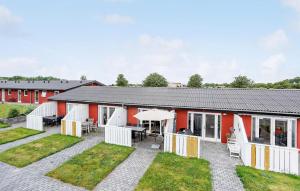 a red and white building with a patio and grass at Cozy Apartment In Aakirkeby With Wifi in Åkirkeby +11 photos