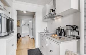 a kitchen with white cabinets and a counter top at Cozy Apartment In Aakirkeby With Wifi in Åkirkeby