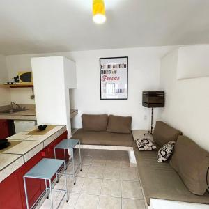 een woonkamer met een bank en een keuken bij INMOTEGA - Suites TG in San Luis Potosí